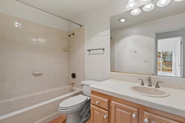 full bathroom with toilet, tiled shower / bath combo, and vanity