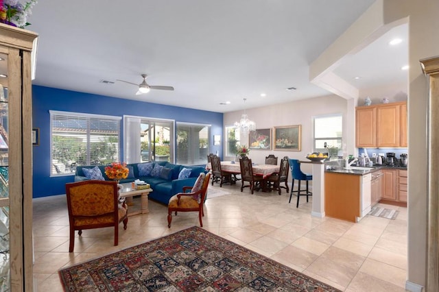 living room featuring ceiling fan with notable chandelier and light tile patterned floors