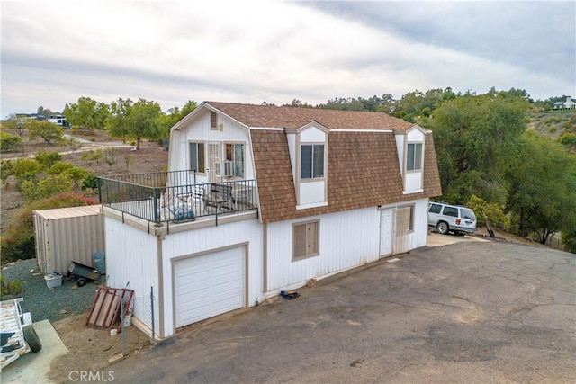 view of front of home featuring a balcony and a garage