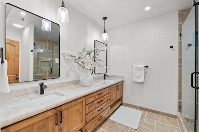 bathroom featuring a shower with shower door and vanity