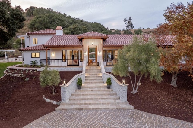 mediterranean / spanish house featuring covered porch