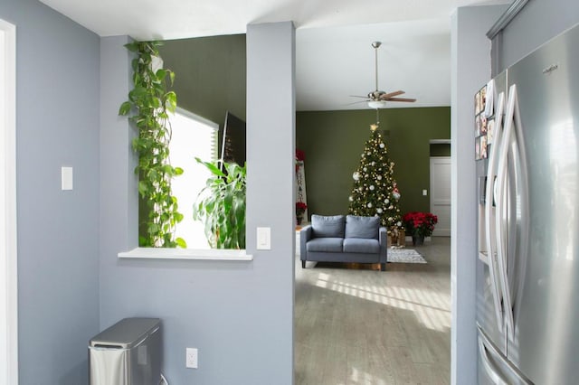 interior space with ceiling fan, stainless steel fridge with ice dispenser, gray cabinetry, and hardwood / wood-style floors