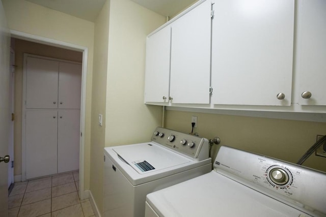 washroom featuring cabinets, washer and clothes dryer, and light tile patterned flooring