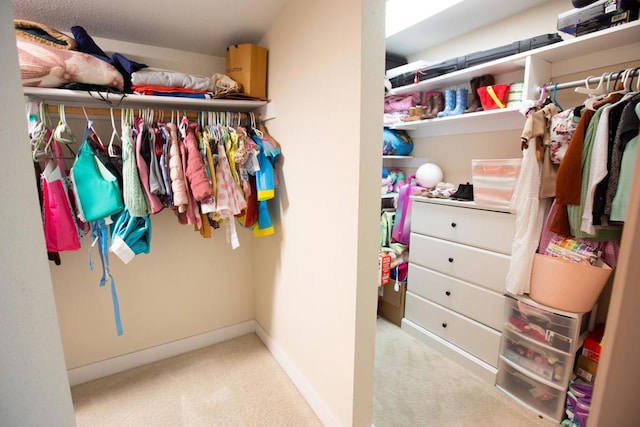 walk in closet featuring light carpet