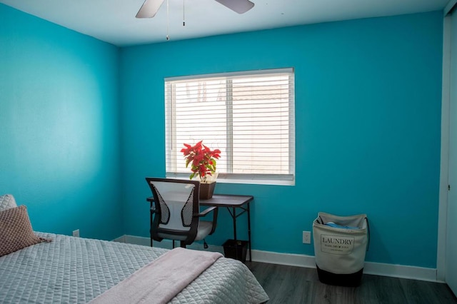 bedroom with ceiling fan, dark wood-type flooring, and multiple windows