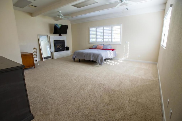 bedroom featuring ceiling fan, light colored carpet, a fireplace, and beamed ceiling