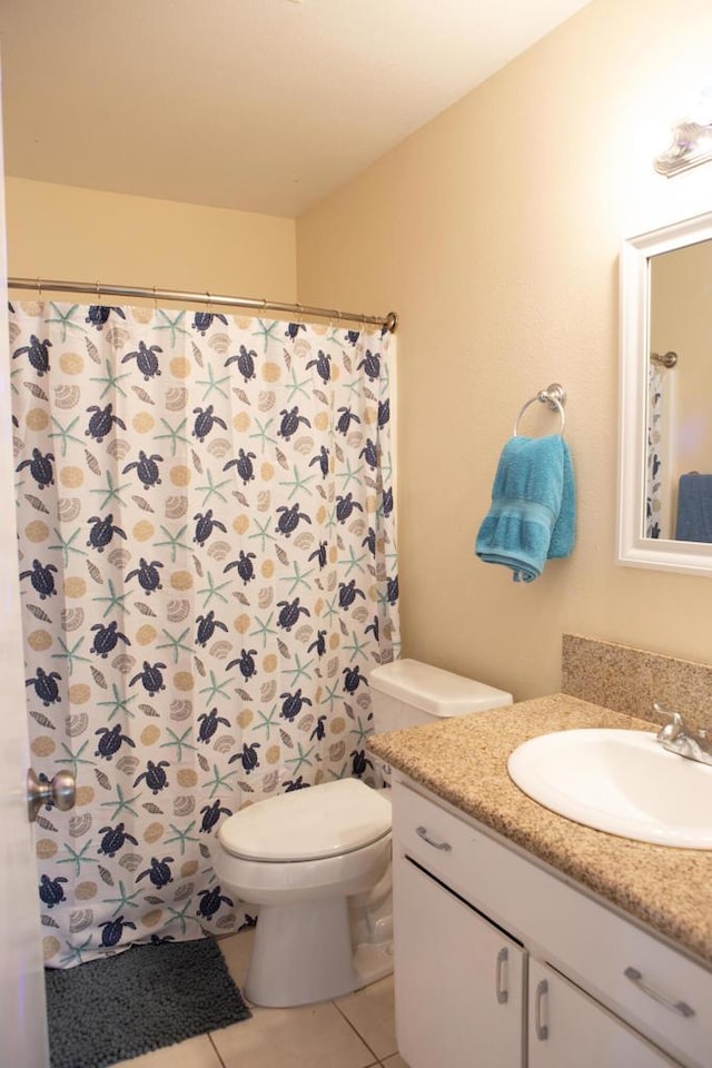 bathroom featuring toilet, vanity, and tile patterned flooring