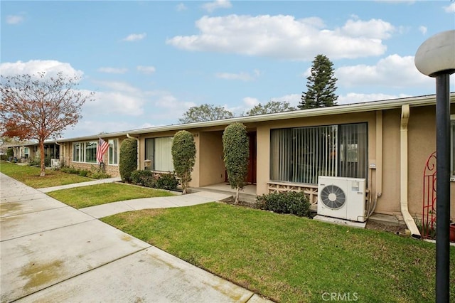 view of front facade featuring a front yard and ac unit