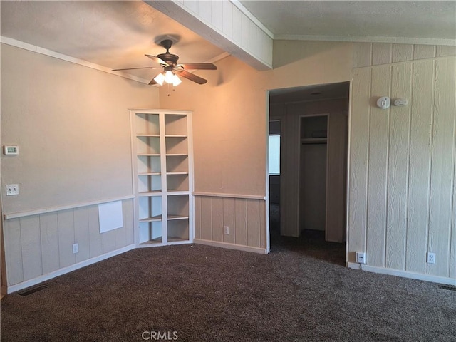 3445 Garfield Ave, Clearlake, CA 95422 - carpeted empty room with ceiling fan, ornamental molding, wooden walls, baseboards, and beamed ceiling