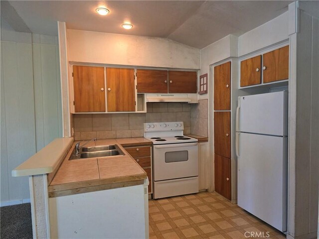 3445 Garfield Ave, Clearlake, CA 95422 - kitchen featuring white appliances, a sink, under cabinet range hood, light flooring, and a peninsula
