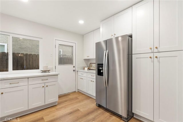 kitchen with white cabinetry, stainless steel fridge with ice dispenser, and light hardwood / wood-style flooring