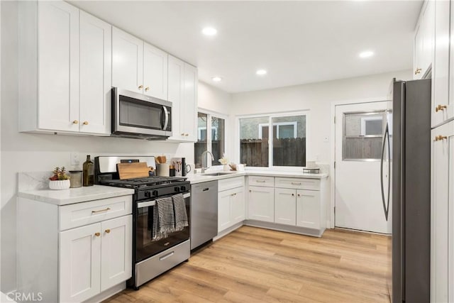 kitchen featuring light hardwood / wood-style floors, sink, white cabinetry, and stainless steel appliances