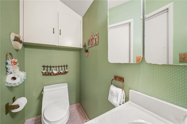 bathroom with toilet and lofted ceiling