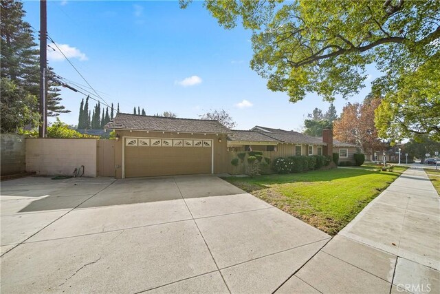 ranch-style home featuring a garage and a front yard