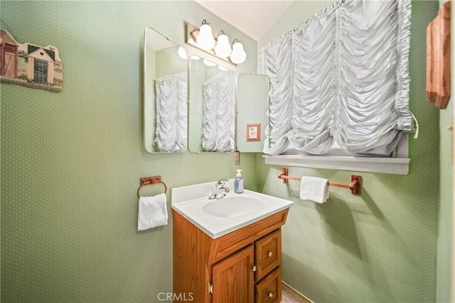 bathroom featuring vanity and lofted ceiling