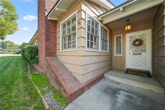 view of exterior entry with a lawn