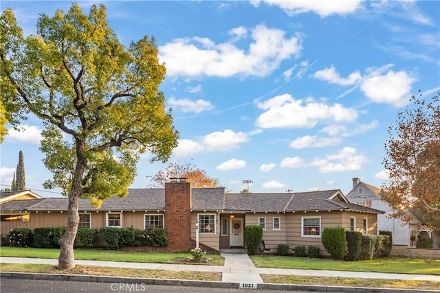 single story home featuring a front lawn