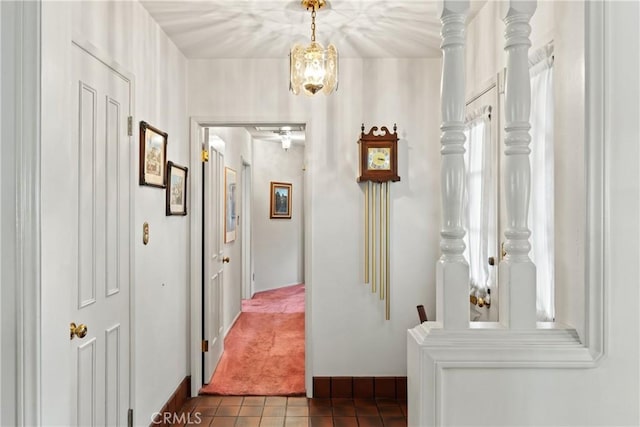 hallway with tile patterned flooring and a chandelier