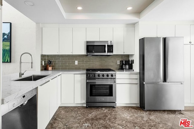 kitchen featuring decorative backsplash, sink, white cabinetry, and stainless steel appliances