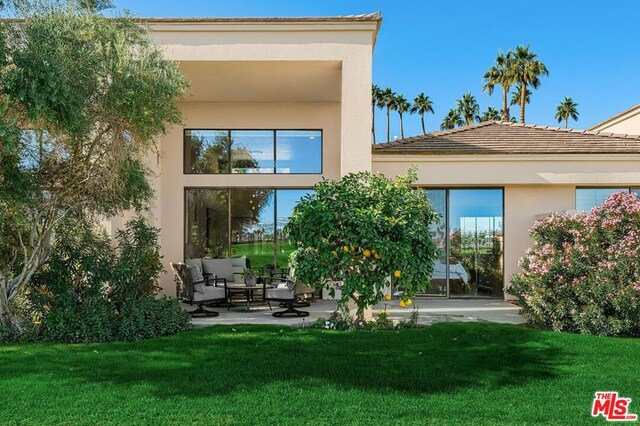 rear view of house with a yard and a patio