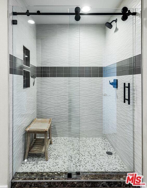 bathroom featuring a shower with shower door