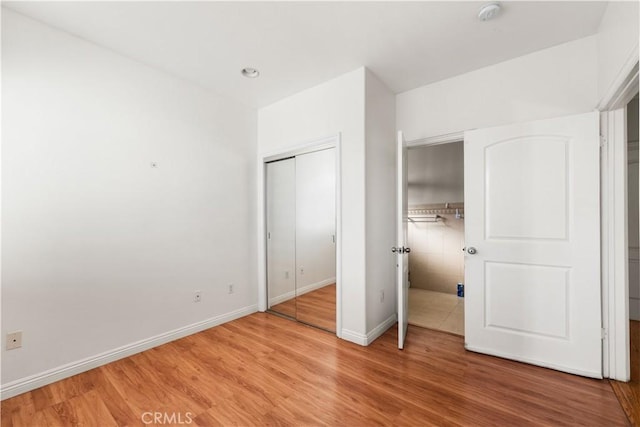 unfurnished bedroom featuring a closet and hardwood / wood-style floors