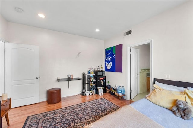 bedroom featuring wood-type flooring and ensuite bathroom