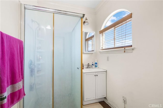 bathroom featuring a shower with door, a wealth of natural light, vanity, and ornamental molding