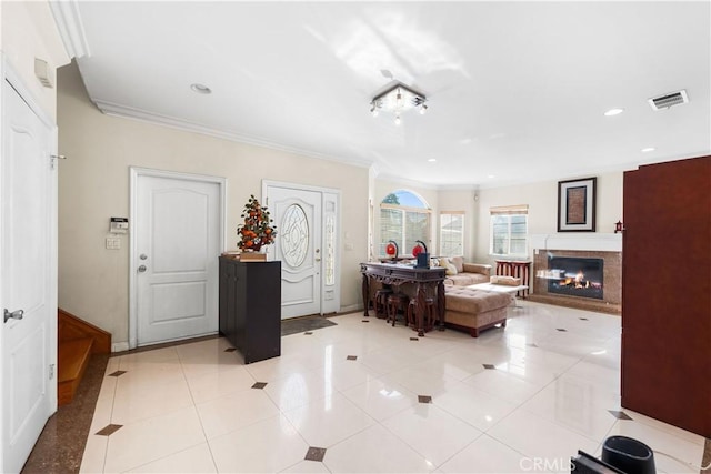 foyer featuring crown molding, light tile patterned floors, and a multi sided fireplace