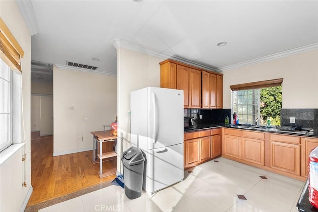 kitchen featuring light tile patterned floors, white refrigerator, and ornamental molding