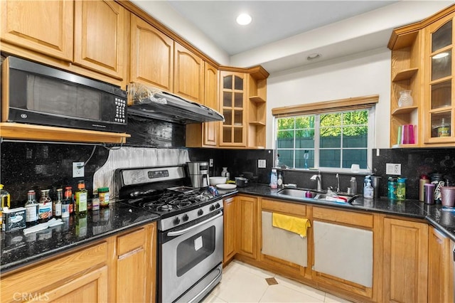 kitchen with backsplash, stainless steel gas range oven, sink, and dark stone countertops