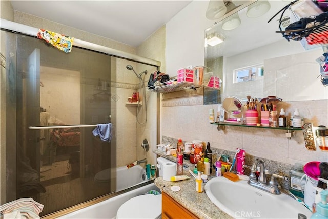 full bathroom with toilet, tile walls, enclosed tub / shower combo, and vanity