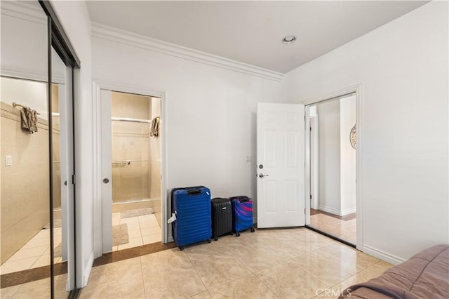 tiled bedroom with a closet and ornamental molding