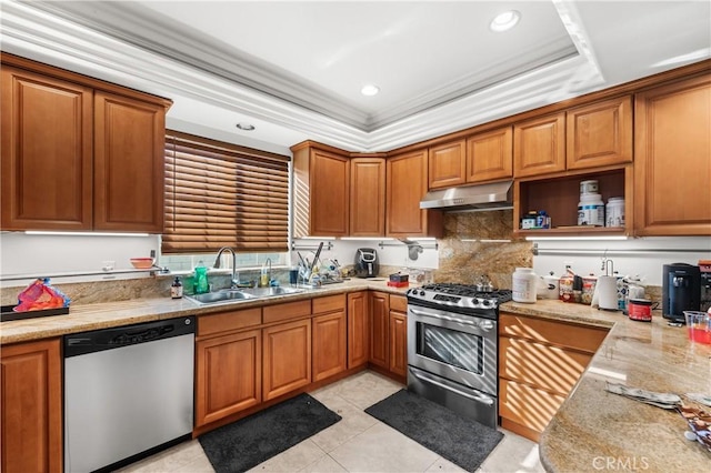 kitchen with sink, a tray ceiling, appliances with stainless steel finishes, ornamental molding, and light tile patterned floors