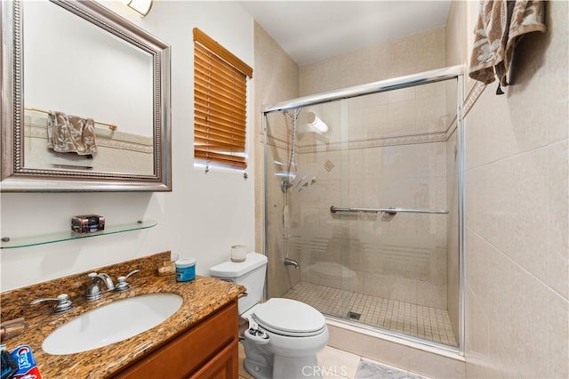 bathroom featuring toilet, tile patterned flooring, walk in shower, and vanity