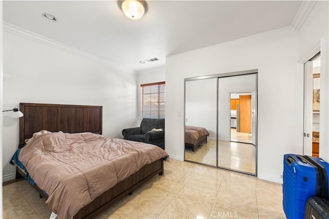 bedroom featuring a closet, light tile patterned flooring, and crown molding