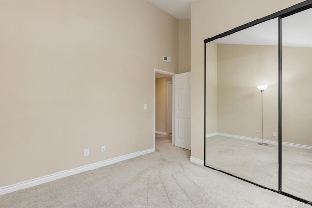 unfurnished bedroom with a closet and light carpet