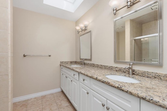 bathroom with a shower with shower door, vanity, a skylight, and tile patterned flooring