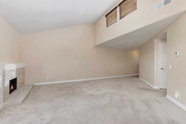 unfurnished living room with light carpet and a fireplace