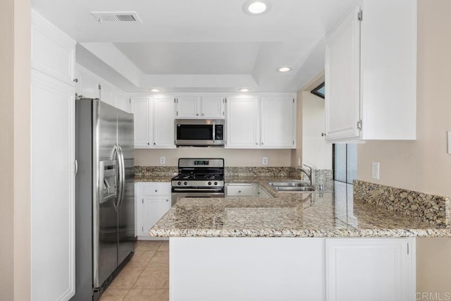 kitchen featuring appliances with stainless steel finishes, white cabinets, kitchen peninsula, and sink