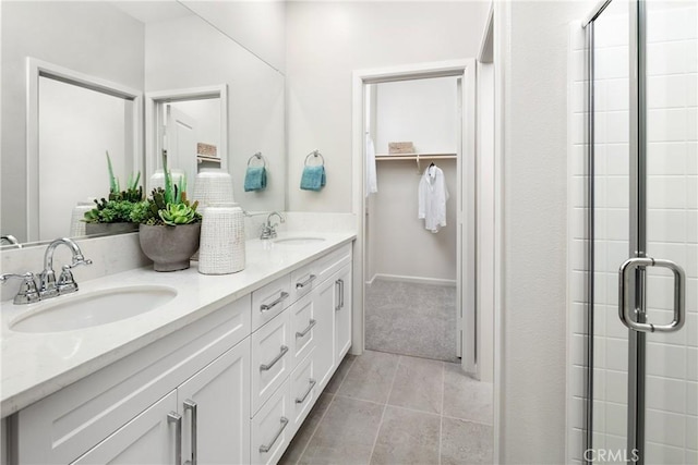 bathroom with tile patterned flooring, vanity, and a shower with door