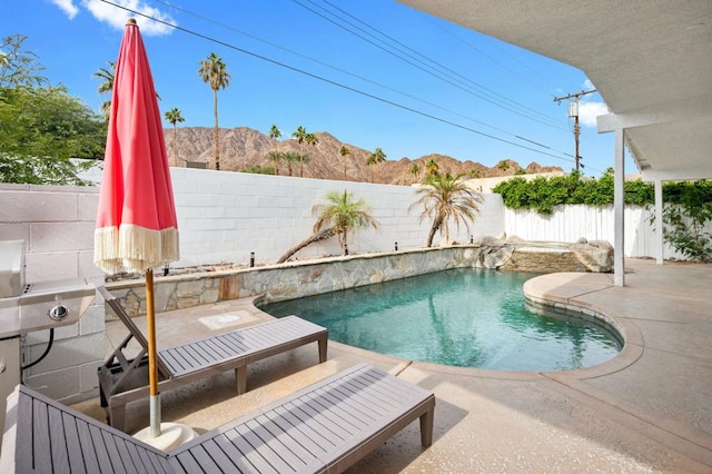 view of swimming pool featuring a patio area and a mountain view