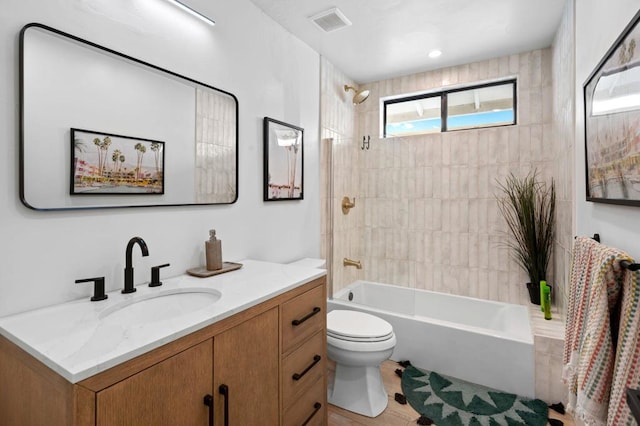 full bathroom featuring toilet, vanity, and tiled shower / bath