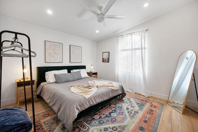 bedroom featuring ceiling fan, light hardwood / wood-style flooring, and vaulted ceiling