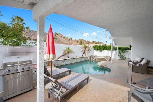 view of pool featuring a mountain view, area for grilling, and a patio