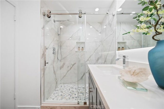 bathroom featuring vanity and a shower with door