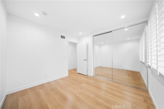 unfurnished bedroom with a closet and light hardwood / wood-style flooring