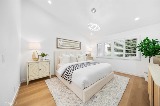 bedroom with lofted ceiling and light wood-type flooring