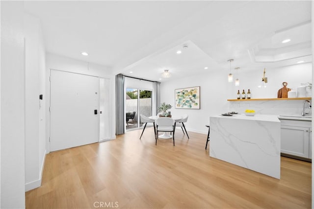 dining area featuring light wood-type flooring and bar