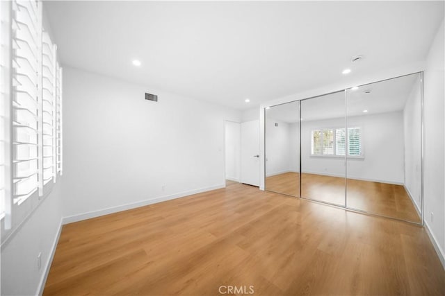 unfurnished bedroom with wood-type flooring and a closet